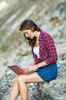 Office outdoors. Beautiful girl works on a laptop in the open air. woman freelancer. Freelance worker concept. photo