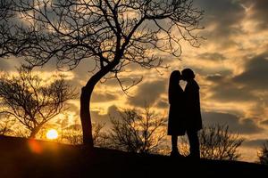 silueta de pareja romántica enamorada, hombre y mujer en el cielo del atardecer. romántico de las relaciones entre el amor de pareja en el jardín foto