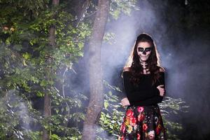 retrato de mujer vampiro de halloween sobre fondo de noche de miedo. diseño de arte de moda de maquillaje de vampiro. chica modelo disfrazada de halloween y maquillada. foto