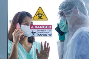 covid-19, propagación de la epidemia de cuarentena del brote del virus de la corona y concepto de distanciamiento social. los médicos asiáticos desdibujan monitorean la salud del paciente y alientan la corona deprimida o la infección del paciente con covid-19 foto