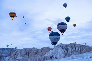 goreme, turquía, 2019- turistas montando el colorido globo aerostático que vuela sobre goreme, paisaje de capadocia foto