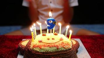 criança está alegremente soprando velas em seu bolo de aniversário video