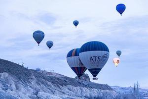 goreme, turquía, 2019- turistas montando el colorido globo aerostático que vuela sobre goreme, paisaje de capadocia foto