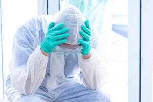 COVID-19, Corona Virus outbreak, quarantine and epidemic spread concept. Asian doctors wear PPE suit, glove and face mask has stress. Doctor has over workload in COVID-19 situation photo