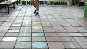 Boy playing hopscotch painting marks at school - boy activity happy play in child school concept video
