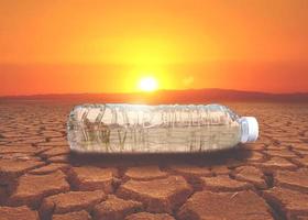 concept of water scarcity Drought due to global warming. Water bottles placed in drought and broken soil areas photo