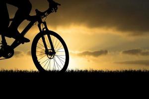 Silhouettes of mountain bikes and cyclists in the evening happily. Travel and fitness concept.  Silhouette of cyclists touring in the evening bicycle touring concept photo