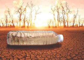 concept of water scarcity Drought due to global warming. Water bottles placed in drought and broken soil areas photo