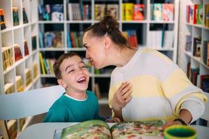 mamá y su hijo pequeño, el hijo de preescolar, leen juntos libros para niños foto