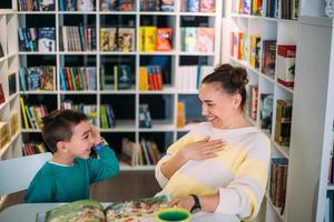 mamá y su hijo pequeño, el hijo de preescolar, leen juntos libros para niños foto