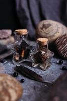 Glass bottles are filled with magical ingredients. Witch's table, stones. photo