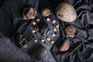 adivinación en runas de madera entre piedras. mesa de brujas sombría y misteriosa. foto