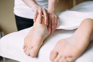 el masajista da un masaje a los pies femeninos en el spa. el concepto de procedimientos cosméticos. foto