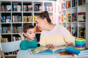 Mom and her little child, the preschooler son, read together children's books photo