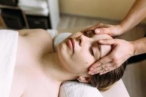 Masseur doing massage on a woman's face at the spa. The concept of cosmetic procedures. photo