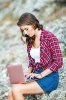 Office outdoors. Beautiful girl works on a laptop in the open air. woman freelancer. Freelance worker concept. photo