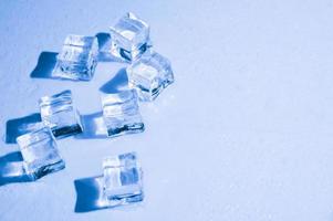 Ice cubes on studio blue background. The concept of freshness with coolness from ice cubes. photo