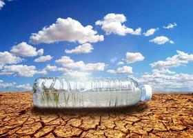 concepto de sequía por escasez de agua debido al calentamiento global. botellas de agua colocadas en áreas de sequía y suelo roto foto