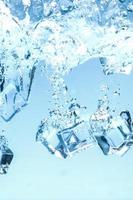 Abstract background image of ice cubes in blue water. photo