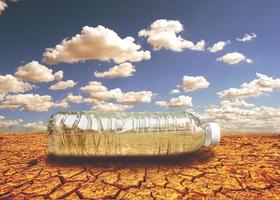 concept of water scarcity Drought due to global warming. Water bottles placed in drought and broken soil areas photo