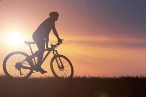 Silhouettes of mountain bikes and cyclists in the evening happily. Travel and fitness concept.  Silhouette of cyclists touring in the evening bicycle touring concept photo