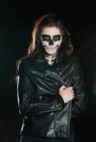 Halloween Vampire Woman portrait over scary night background. Vampire makeup Fashion Art design. Model girl in Halloween costume and make up. photo