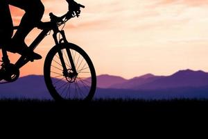 Silhouettes of mountain bikes and cyclists in the evening happily. Travel and fitness concept.  Silhouette of cyclists touring in the evening bicycle touring concept photo