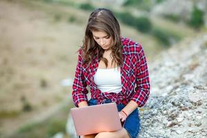 Office outdoors. Beautiful girl works on a laptop in the open air. woman freelancer. Freelance worker concept. photo