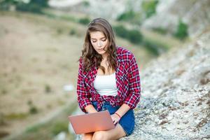 Office outdoors. Beautiful girl works on a laptop in the open air. woman freelancer. Freelance worker concept. photo