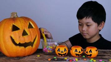 Little kid playing jack o lantern clay and candy in Halloween festival video