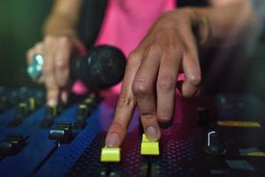 Close-up of female hands on a deejay console with microphone photo