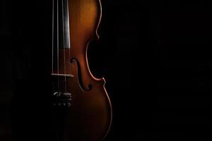 Violin on a black background lit from one side photo