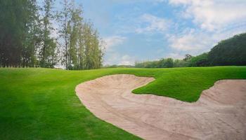 campo de golf en el campo. bunkers de arena en la hermosa puesta de sol, hora del amanecer. hermosa vista del paisaje en la noche hierba verde en el campo de golf. foto