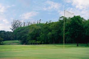 campo de golf en el campo. bunkers de arena en la hermosa puesta de sol, hora del amanecer. hermosa vista del paisaje en la noche hierba verde en el campo de golf. foto