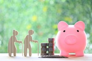 Mutual fund,Love couple senior and stack of coins money with piggy bank on natural green background, Save money for prepare in future and pension retirement concept photo