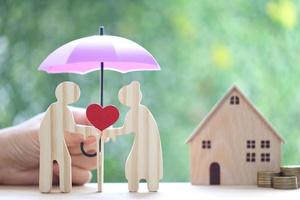 Mutual fund,Love couple senior holding heart shape and hand holding the umbrella with model house on natural green background, Save money for prepare in future and pension retirement concept photo