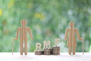 RMF - Retirement Mutual Fund, Love couple senior with RMF word on stack of coins money on natural green background, Save money for prepare in future and pension retirement concept photo