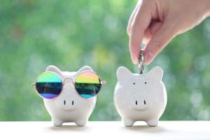 Saving for prepare in future and Business investment concept, Woman hand putting a coin into piggy bank on green background, Finance photo