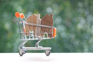 Model house on model miniature shopping cart on natural green background,Mortgage photo