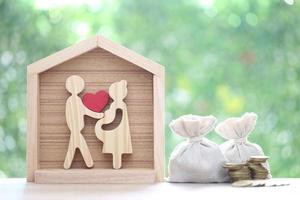 Model family with model house and stack of coins money on natural green background,Save money for prepare in future and family finance concept photo