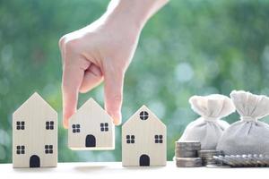 Finance, Model house with and money bag on natural green background,Business investment and Save money for prepare in future concept,Inflation photo