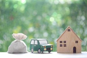 Finance, Model house with the car and money bag on natural green background,Business investment and save money for prepare in future concept,Inflation photo