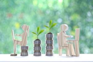 Investment and business concept,Man and woman using laptop computer with stack of coin money on natural green background,Investors strategy photo
