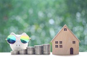 Finance, Model house with stack of coins money on natural green background, Saving money for prepare in future and investment concept photo