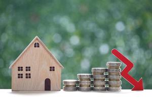 Finance, Model house with stack of coin money and red arrow graph on natural green background,Business investment and Save money for prepare in future concept,Inflation photo
