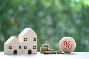 Interest rate up and Banking concept, Model house with Percentage symbol icon and stack of coins money on natural green background, Fixed Rate photo