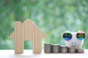 Finance, Model house with stack of coins money on natural green background, Saving money for prepare in future and investment concept photo