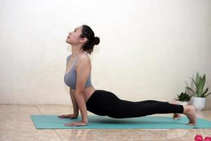 una mujer haciendo ejercicio de yoga en casa foto