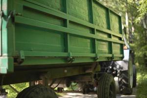 Green tractor trailer. Cart on wheels. Side of trailer. Body of transport. photo