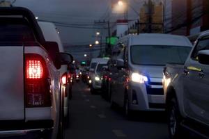 parte trasera abstracta y borrosa del freno de luz abierto del coche bickup por la noche. atasco de tráfico en la ciudad. ambiente nocturno en la ciudad. luz del poste y faros en el lado opuesto del coche. foto